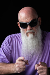 Portrait of man with long gray beard wearing purple t-shirt and sunglasses pointing finger at camera