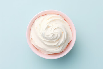 Overhead view of delicious vanilla milk ice cream in a round pink vase isolated on a light pastel blue background. Copy space for text. Generative AI photo.
