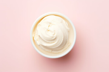 Overhead view of delicious vanilla milk ice cream in a round white vase isolated on a light pastel pink background. Copy space for text. Generative AI photo.