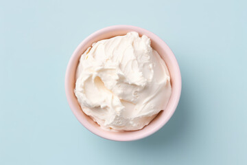 Overhead view of delicious vanilla milk ice cream in a round pink vase isolated on a light pastel blue background. Copy space for text. Generative AI photo.