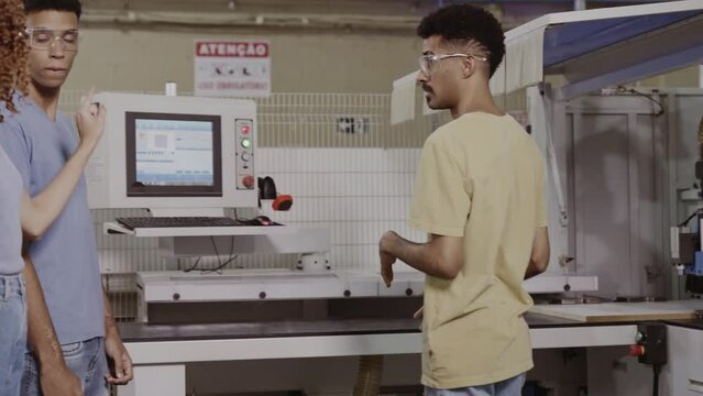 teacher at a technical school in Brazil giving a practical class in an industrial environment