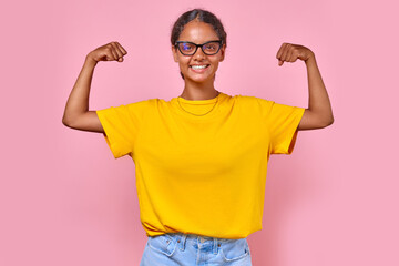 Young strong confident Indian woman teenager showing biceps to demonstrate self-confidence and...