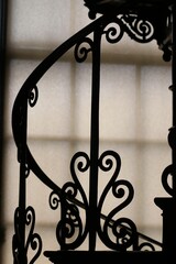 Vintage-style metal railing silhouetted against a bright window