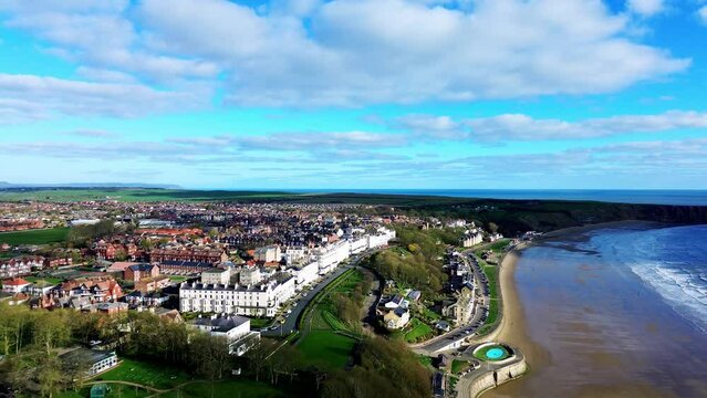Drone footage over Filey seafront and Espalande showing gardens and new buildings by the water, UK