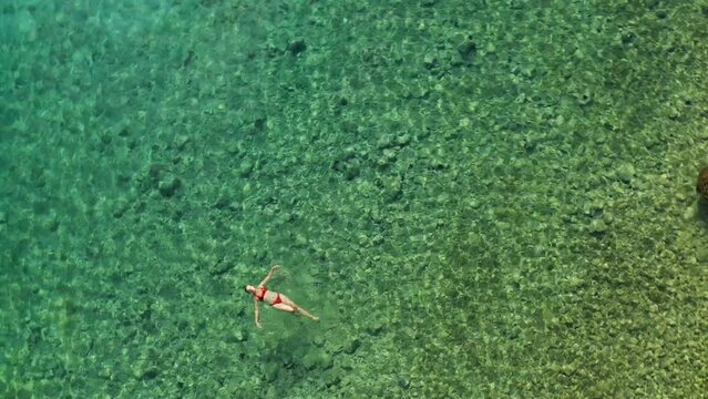 Aerial view of a young woman swimming on the Adriatic Sea near Rab Island, Croatia