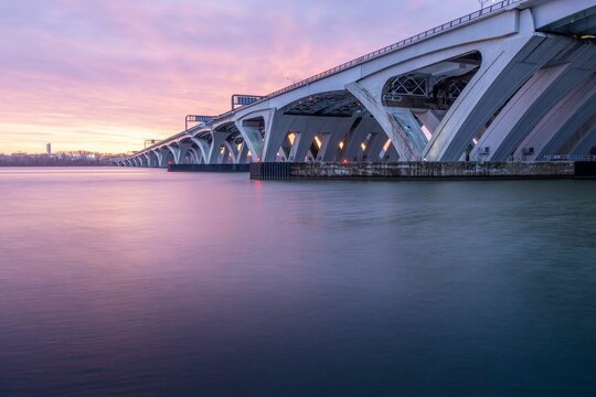 Beautiful sunset over an overpass bridge that arcs across a tranquil lake or river