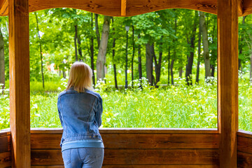 woman in a wooden gazebo watching nature