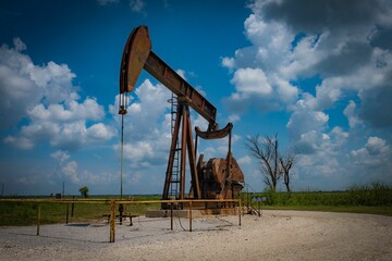 Fototapeta premium Landscape featuring an oil derricks set against a beautiful blue sky