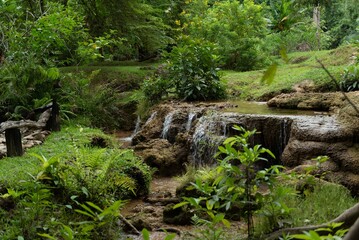 Grueng Kra Wieng waterfall cascades through a vibrant, green forest in Khao Laem National Park