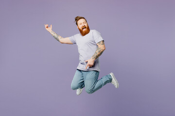 Full body young redhead bearded man he wear violet t-shirt casual clothes jump high pov playing...