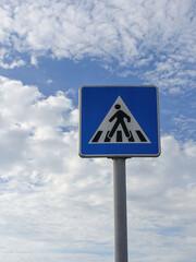 Pedestrian crossing traffic sign against cloudy sky