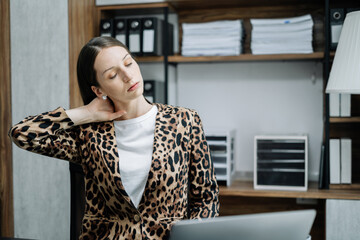 Businesswoman is doing a stretchy posture due to sitting in the office for too long, office syndrome concept.