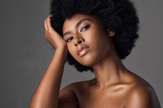 African woman, beauty and studio portrait with afro, skincare and cosmetics by grey background. Girl, model and healthy with natural glow on skin with makeup, clean aesthetic and wellness for face