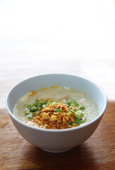 Congee in a bowl with fried garlic and onion