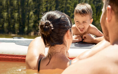 Happy, family with boat and in lake together with smile for bonding time. Summer vacation or...