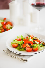 Fresh salad with mussels and tomatoes on white wooden table