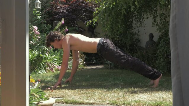 A young man performing a Spinx Variation pushup