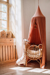 Woven cot with red textile baldachin in kids room © brizmaker