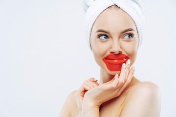 Beautiful woman wears lip hydrogel mask, smooth skin, minimal makeup, tries new cosmetic.