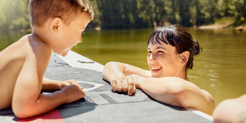 Happy, mother with child and with boat in lake together with smile for bonding time. Summer...