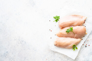 Chicken fillet, raw chicken meat breast with spices at white background. Top view with space for text.