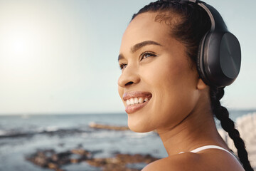 Headphones, fitness and happy woman at beach for exercise, vision or running mindset, goals or...