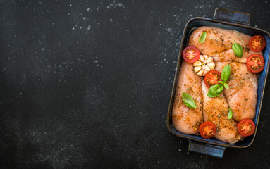Chicken fillet, raw chicken meat breast with spices and vegetables in the pan. Top view with space for recipe, ready for cooking in the oven.