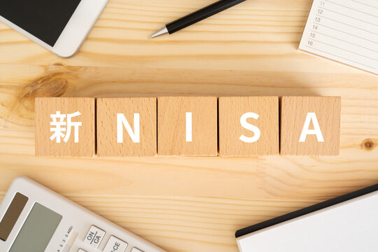 新NISAと書かれたブロック、電卓、スマホ、ノート