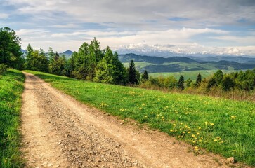 Fototapeta na wymiar Spring landscape in Polish mountains. Mountain trail and forested hills.