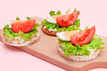 Rice Cake Sandwiches with Tomato, Lettuce and Egg on Wooden Cutting Board. Easy Breakfast. Diet Food. Quick and Healthy Sandwiches. Crispbread with Tasty Filling. Healthy Dietary Snack