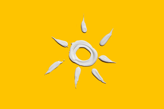 sun  drawn with sunscreen on a yellow background