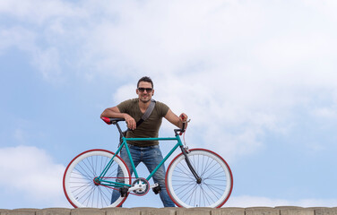 Fototapeta premium Urban man wearing sunglasses on a cloudscape