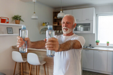 Fototapeta na wymiar Elder man using bottle of water for home workout.