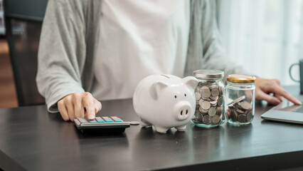 Close up young woman saving money for household payments coin,  piggy bank, mutual fund, mixed...