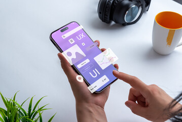 Process of creating an interface for a mobile app. User interface and experience concept. Modern app on smart phone in woman hands - obrazy, fototapety, plakaty