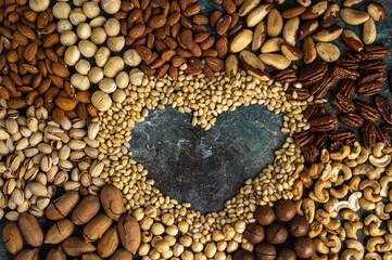 Assorted nuts with a heart in the middle of the composition. Healthy organic food.
