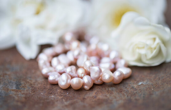 Natural freshwater pearls of various shapes and colors are photographed on a metall 