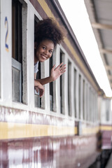 Young asian travel by train sticking her head out of the train, Happy smiling woman female girl looks out from train window travelling by train