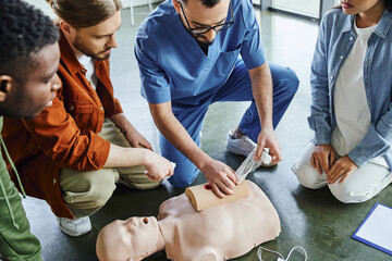 high angle view of professional paramedic tamponing wound on simulator with bandage during first aid seminar with diverse multiethnic group, life-saving skills and emergency response concept - Powered by Adobe