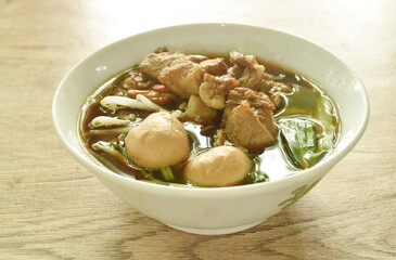 braised pork with meatball in herb brown soup on bowl 