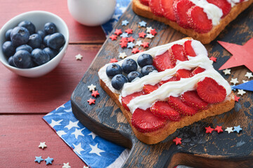 4th of July American Independence Day food. American flag sandwich with strawberries, blueberries, whipped sweet cream, soft cheese on toast bread. Independence or Patriotic Day breakfast idea Mock up
