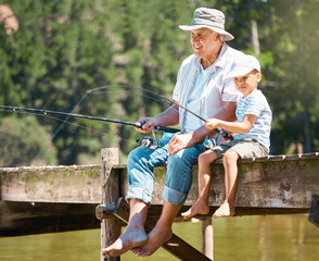Grandfather, boy and fishing rod at lake for hobby, adventure and teaching about nature. Young child, senior man and learning to fish at water by river dock, weekend camping trip and outdoor holiday
