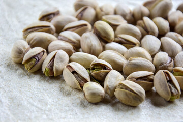 Tasty pistachio nuts on the background of crumpled craft paper. Healthy organic food. Pistachios in shell as background and texture. Close-up. Copy space. Selective focus.