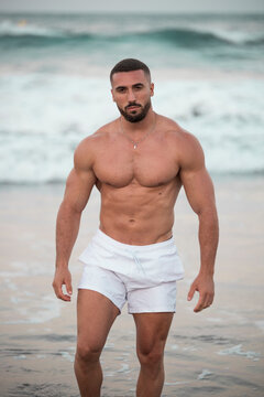 El cuerpo masculino perfecto - Impresionante simulador de cuerpos posando en ba&ntilde;ador. Joven musculoso sin camiseta en la playa mirando a c&aacute;mara de manera seductora. Espacio para texto