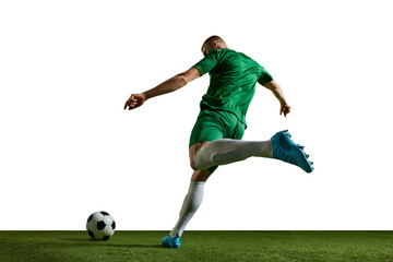 Fototapeta premium Young man, football player in green uniform in motion, kicking ball, training, playing against white background. Concept of professional sport, action, lifestyle, competition, hobby, training, ad