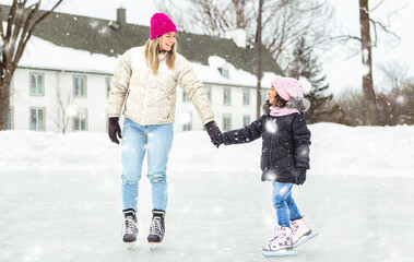 little girl skater in a winter park having fun with her daughter