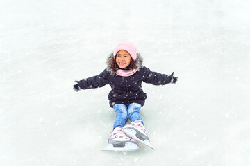 Fototapeta na wymiar little girl skater in a winter park having fun