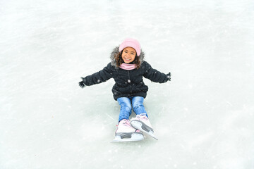 little girl skater in a winter park having fun