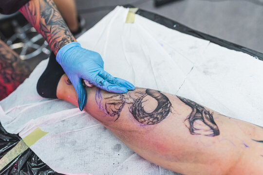 closeup shot of a customer getting a new tattoo on a leg in the art studio. High quality photo