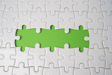 Jigsaw puzzle on green background, business teamwork, problem solving concept.